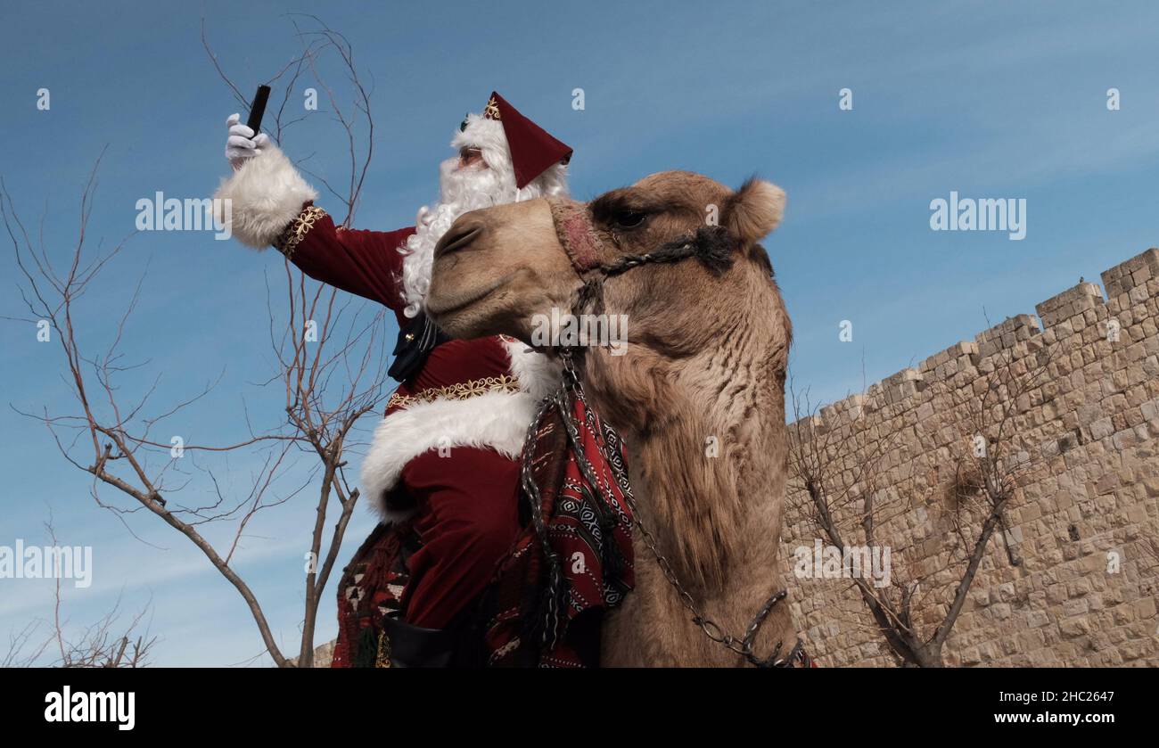 Issa Kassissieh an Arab Orthodox Christian and Israel’s only certified Santa Claus takes a selfie in front of the old city in Jerusalem Israel Stock Photo