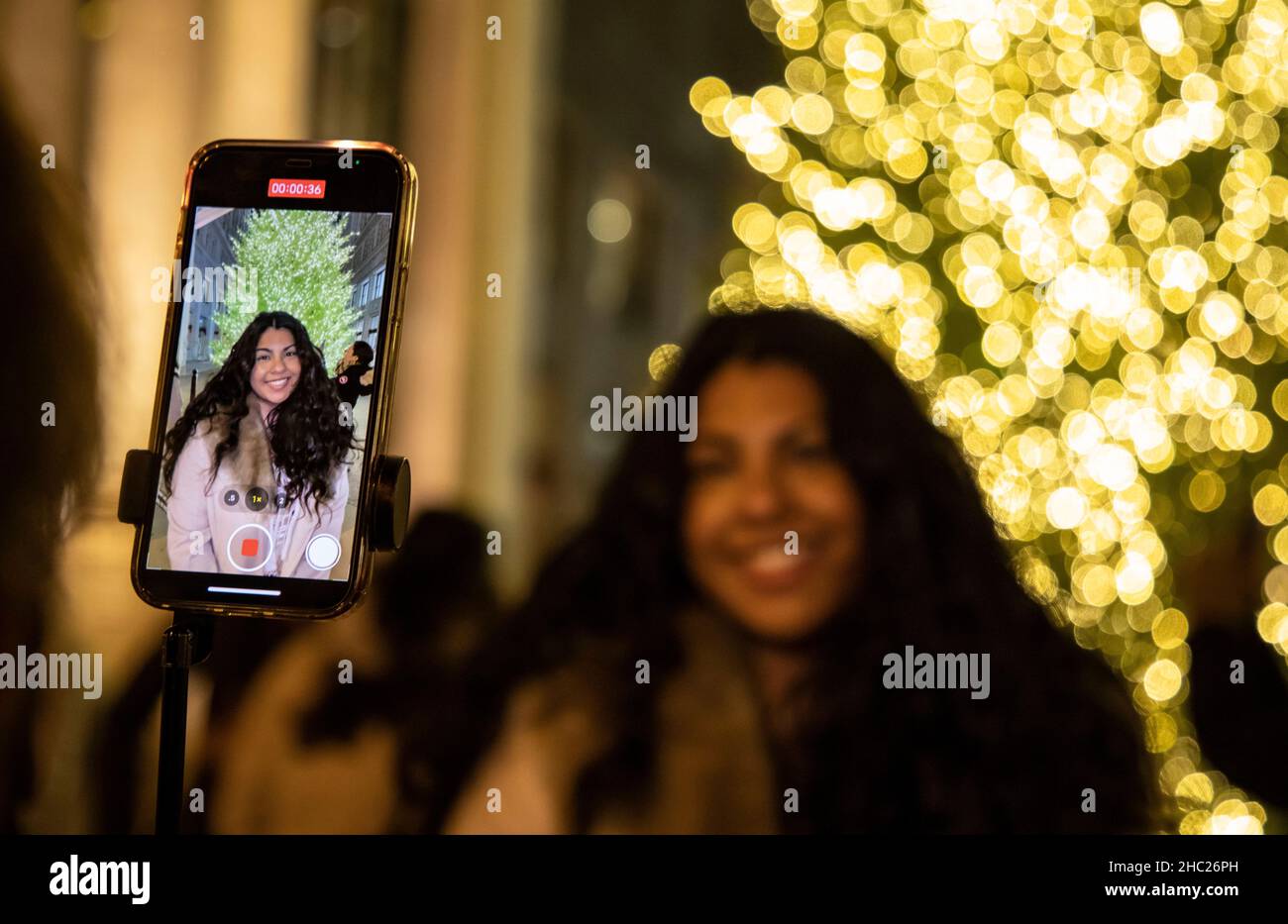 Chicago, USA. 19th Dec, 2021. A woman has her photo taken with a Christmas tree on Michigan Ave. in Chicago, the United States, Dec. 19, 2021. Credit: Joel Lerner/Xinhua/Alamy Live News Stock Photo