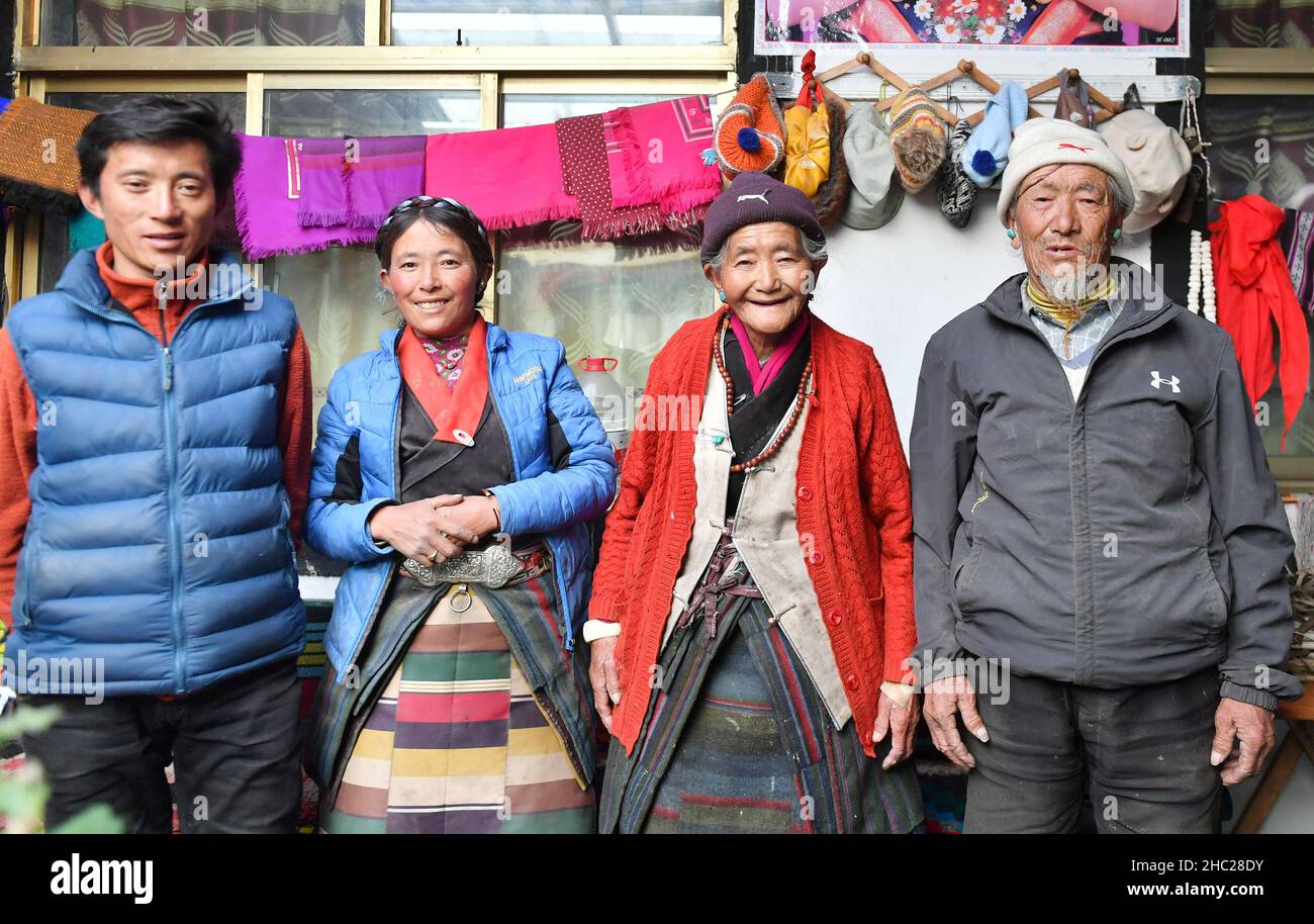 (211219) -- LHASA, Dec. 19, 2021 (Xinhua) -- Photo taken on May 13, 2021 shows the group photo of Tsering Dondrup (R) and his family members in Jianggang Village of Nyalam County, Xigaze City of southwest China's Tibet Autonomous Region. Born in 1947, Tsering Dondrup lives in Jianggang Village, Nyalam County of Tibet.    Tsering and his family members served as enslaved farmers for their serf owner in old Tibet. Drudgeries including farming, collecting firewood and cow dung fell on them with little rations could be earned from serf owner. When it came to harvest, the ripe highland barley they Stock Photo