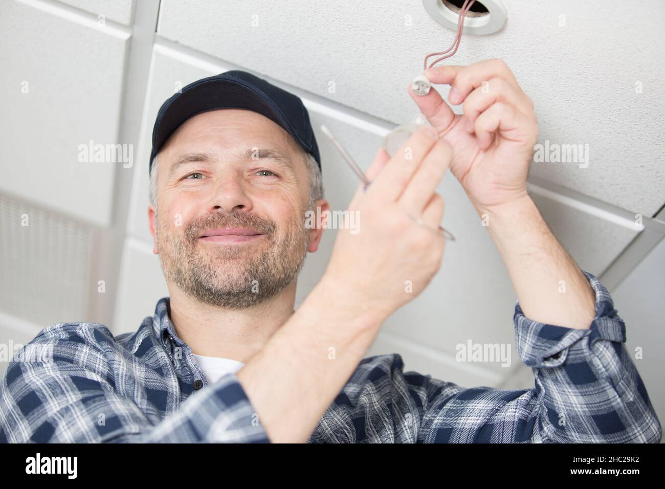 handyman changing spotlight bulb in ceiling Stock Photo Alamy