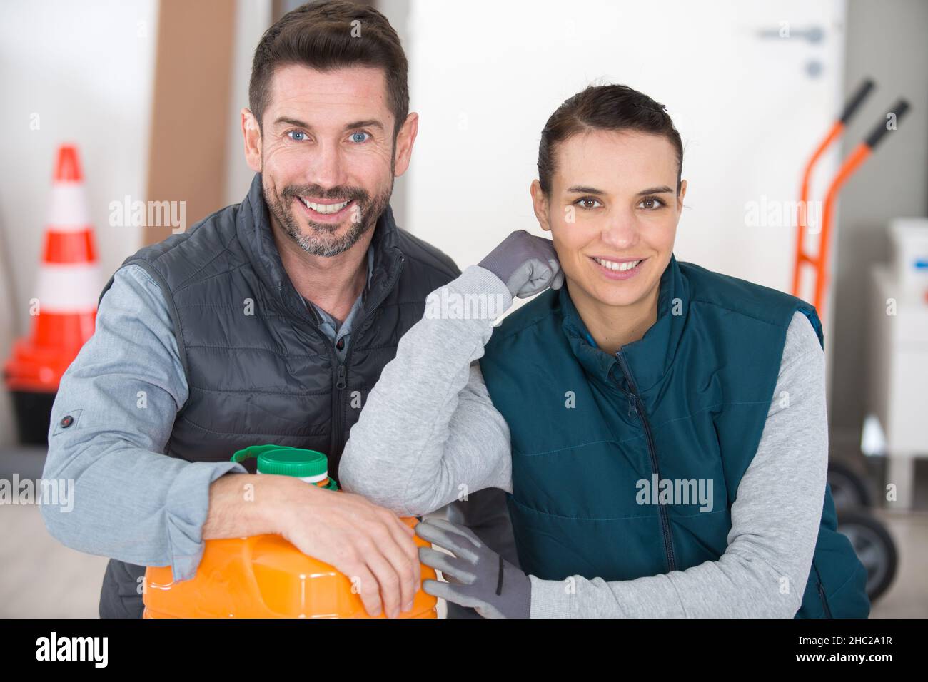 two workers leaning on plastic container in factory Stock Photo