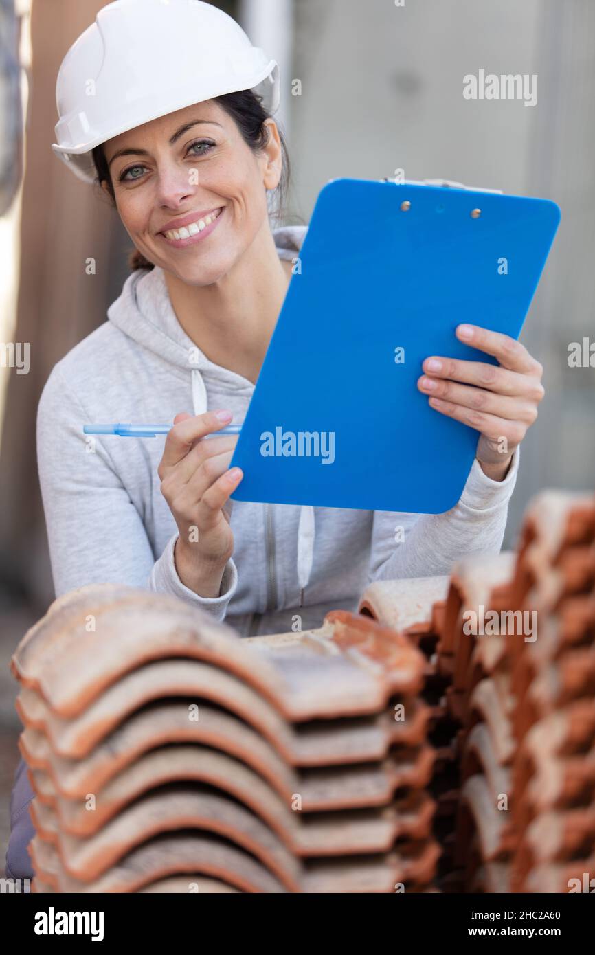 female builder in hardhat with clipboard Stock Photo