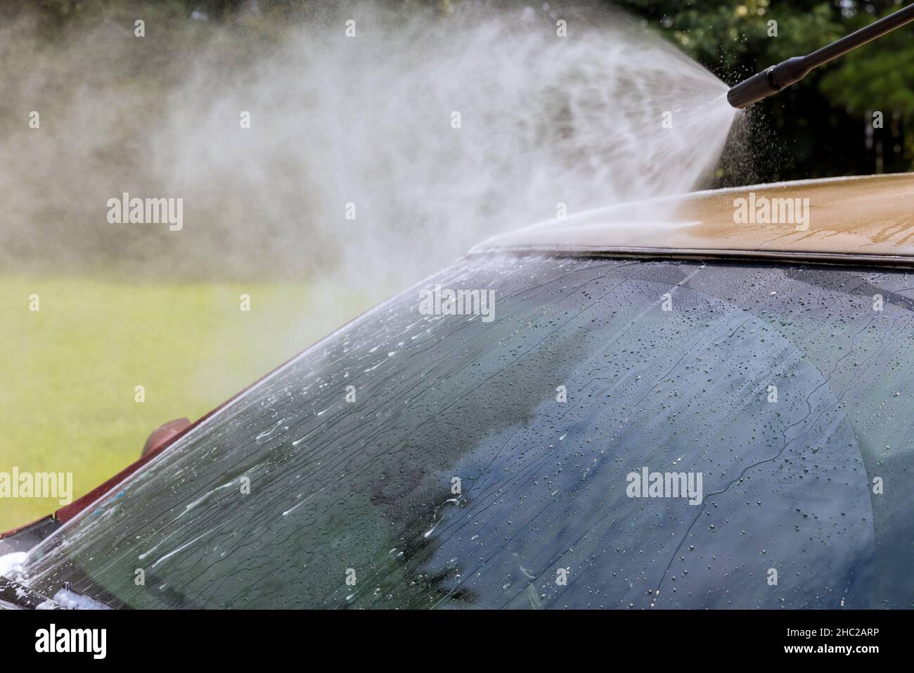 Detail on car front being washed with jet water in a car wash Stock