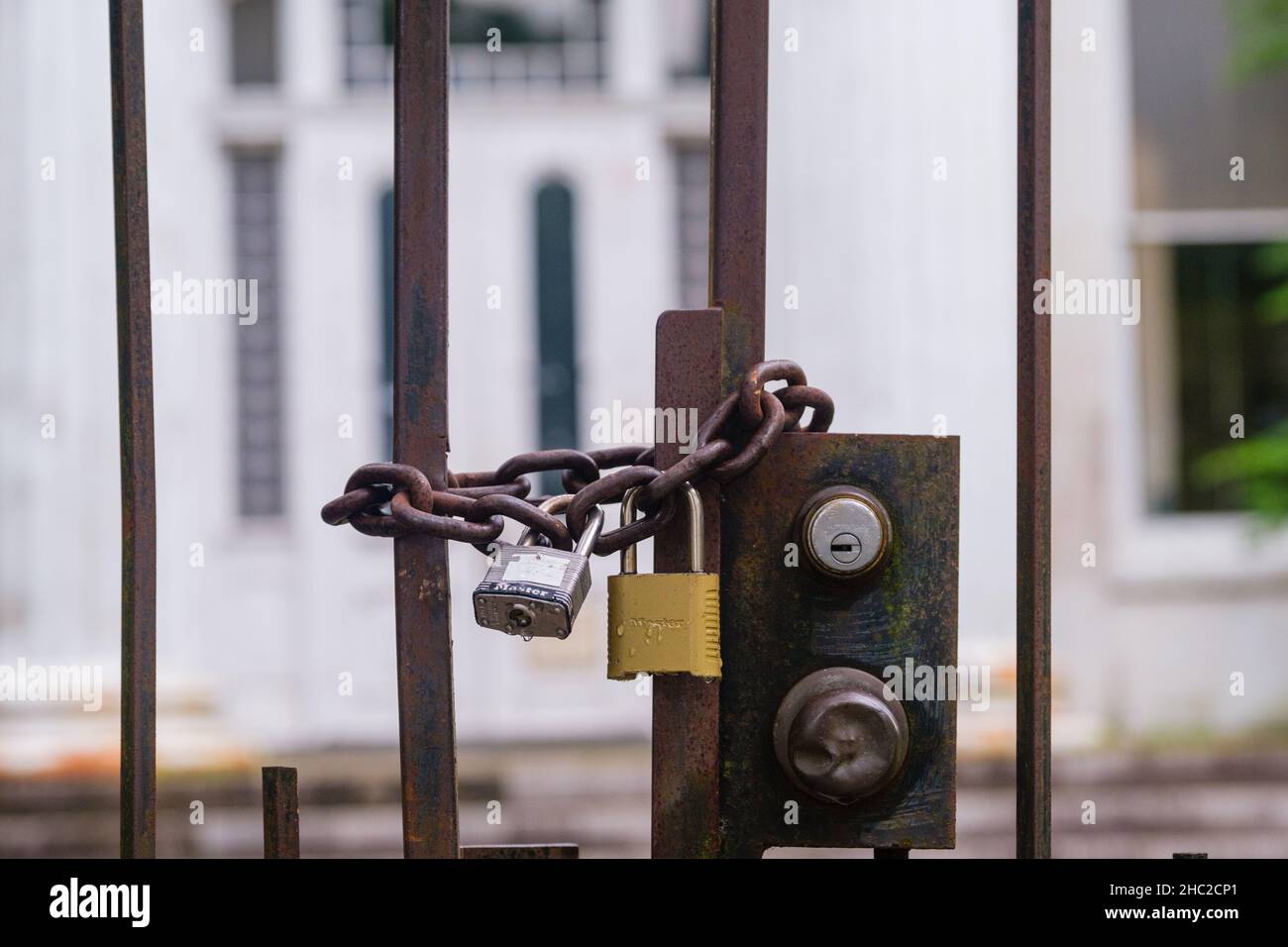 NEW ORLEANS, LA, USA - JUNE 23, 2020 - Pair of locks securing a heavy chain on an iron gate Stock Photo