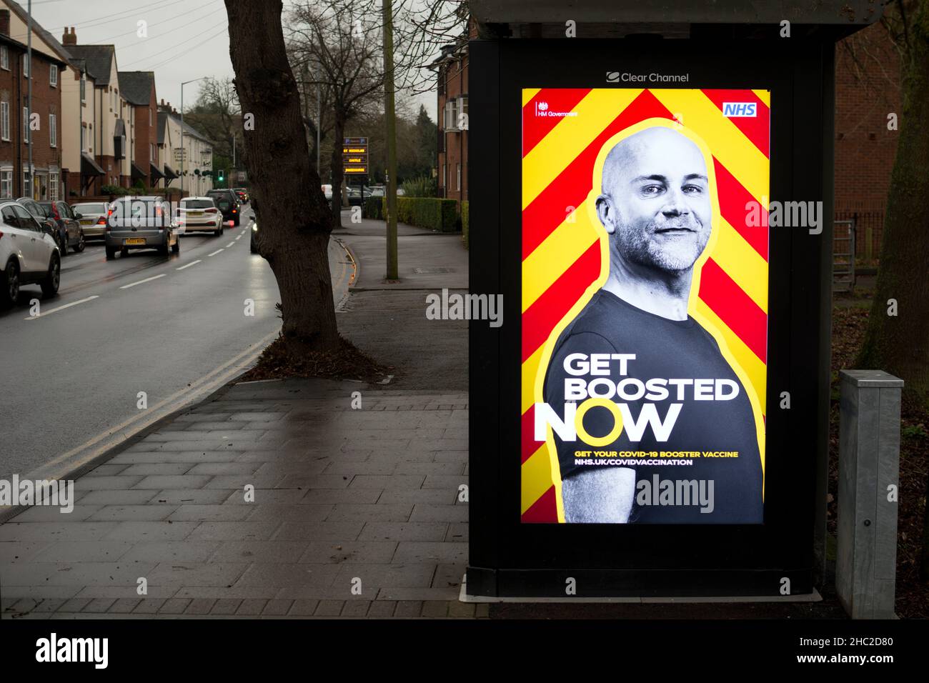 Illuminated 'Get Boosted Now' poster on a bus shelter, Warwick, UK. December 2021. Stock Photo