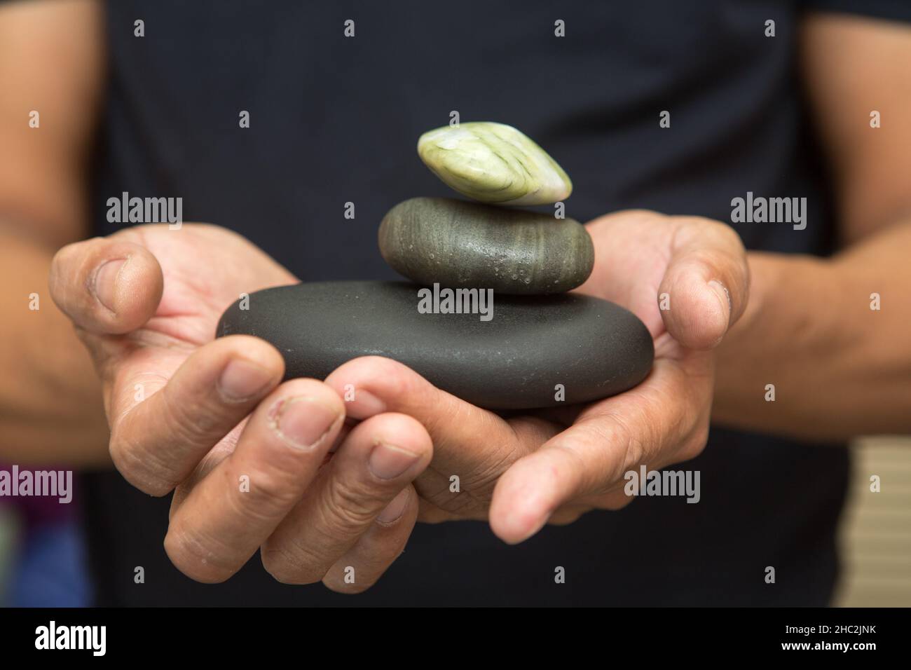 Stones for stone therapy in the hands.Stone therapy is one of the types of massage, stone massage Stock Photo