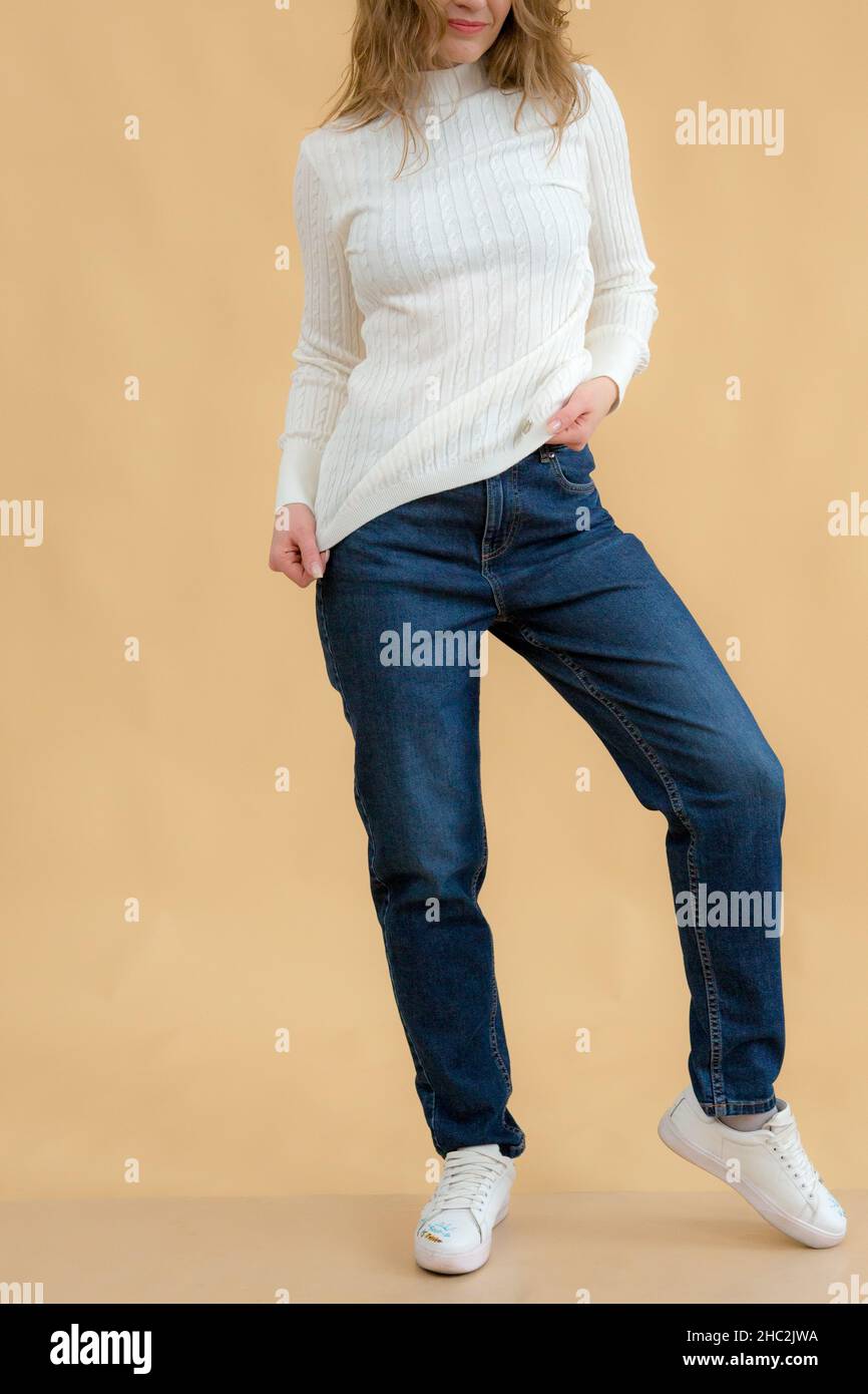 A woman in clothes on the background in the studio, fitting clothes Stock Photo