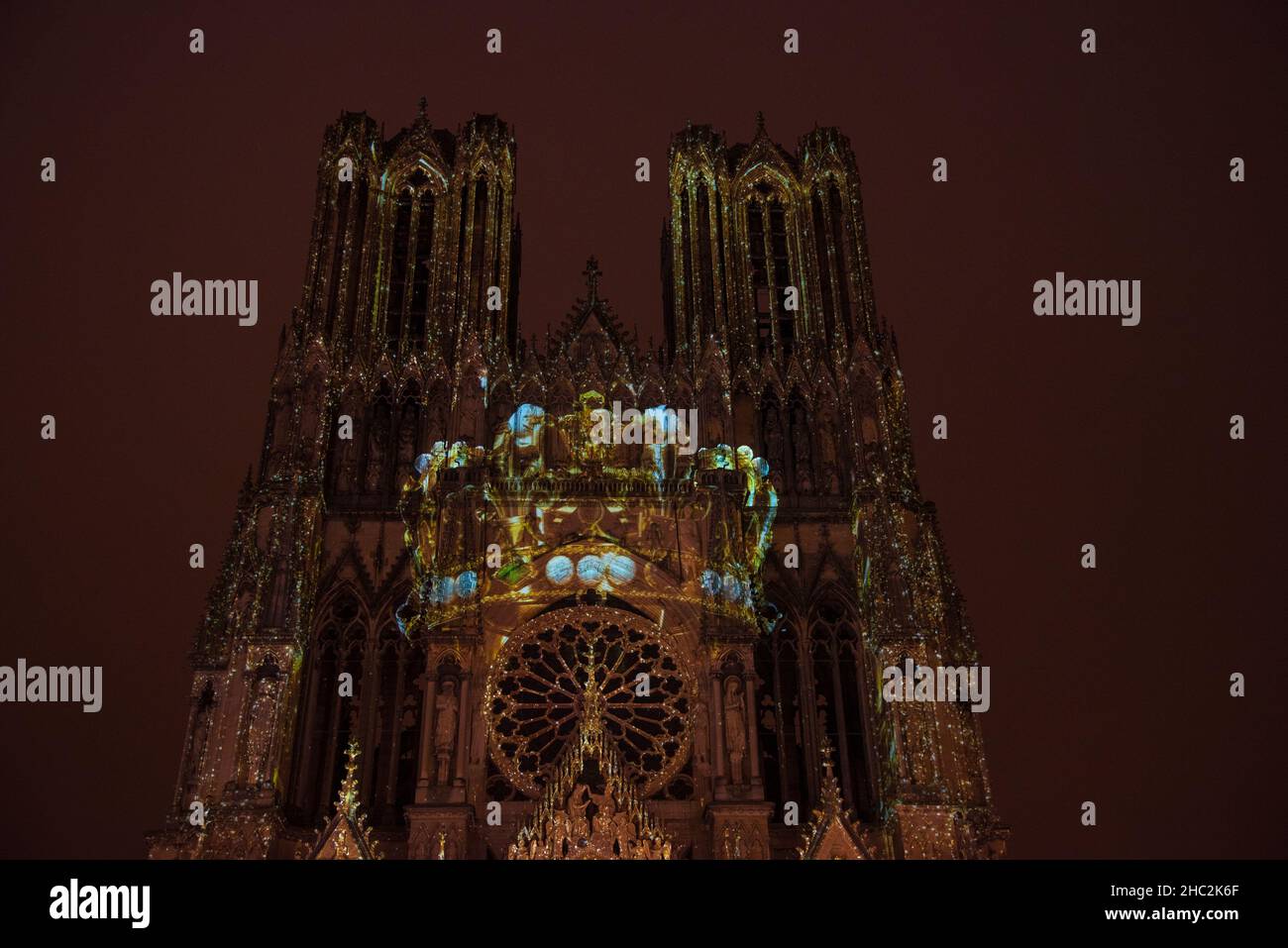 Reims, France - December 19, 2021: Colorful Christmas lights show on Reims Cathedral facade. Royal crown Stock Photo