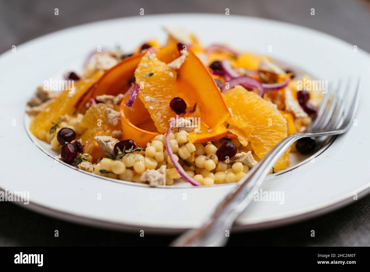 Salad with marinated winter squash,  oranges and vegan feta on perl couscous. Stock Photo