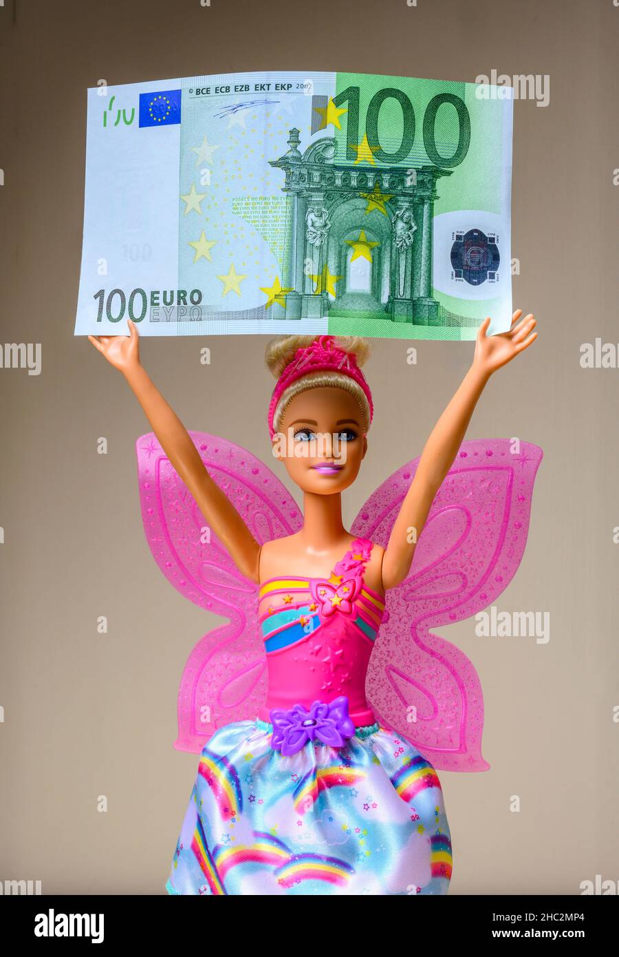 Barbie doll holding a 100 Euro banknote, Stock Photo