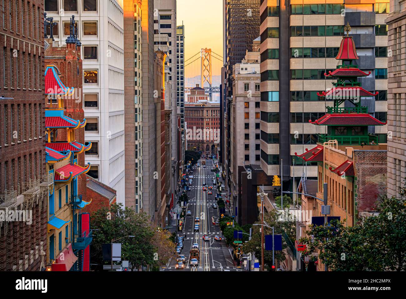 Famous view of California Street near China Town and the Financial District, with Chinese pagoda towers and the Bay Bridge at sunset in San Francisco Stock Photo
