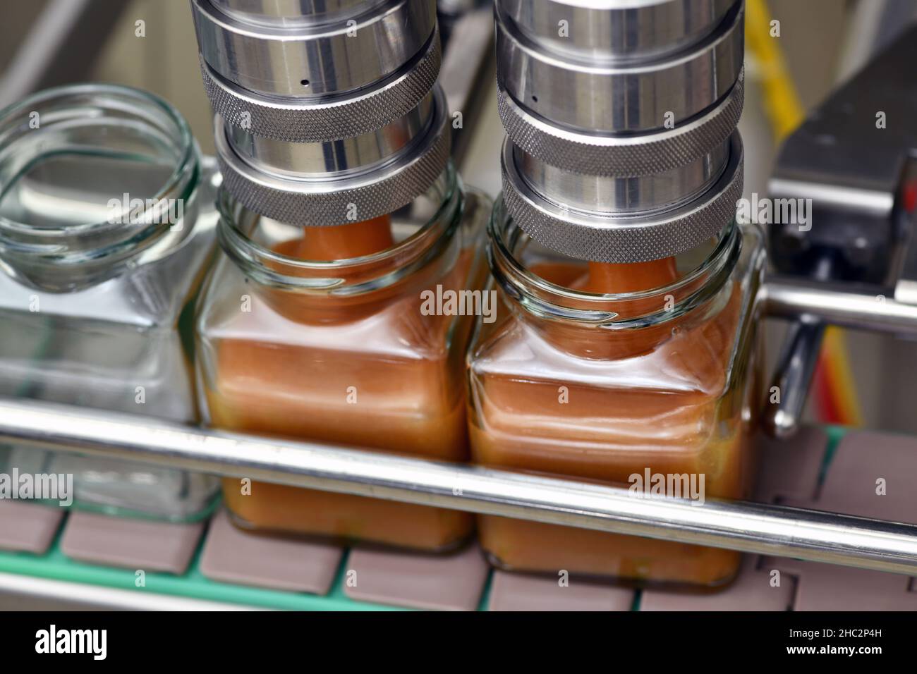 Jars of creamed honey in a packaging line at a commercial honey factory