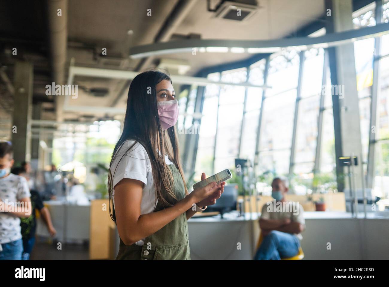 Young woman wearing mask uses hi-res stock photography and images - Alamy