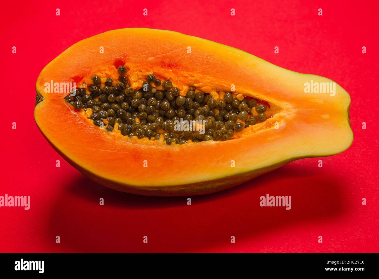 Papaya fruit on a orange background. Tropical fruit. Half papaya Stock Photo Alamy