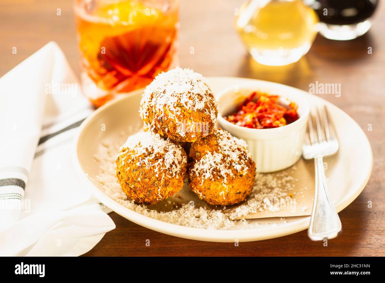 fried risotto balls and a negroni cocktail Stock Photo