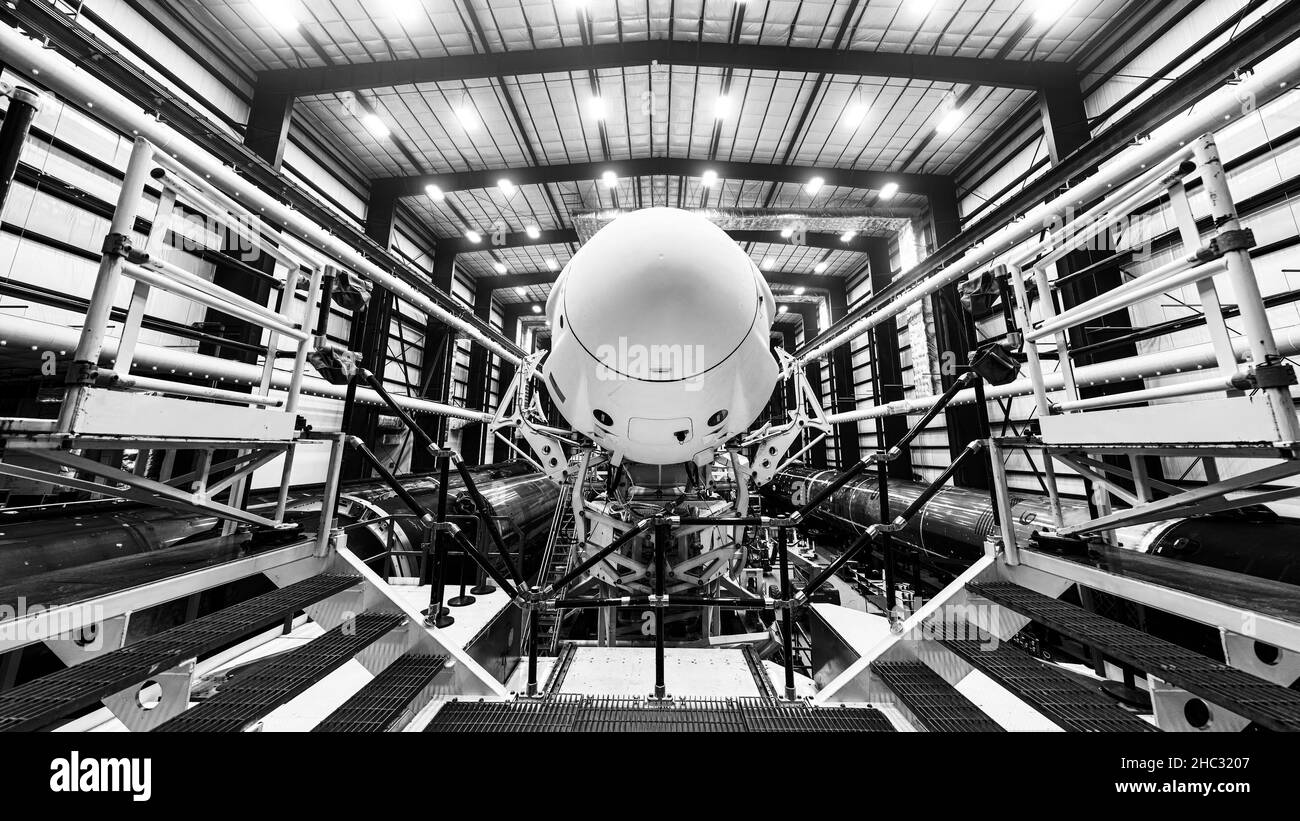 Space launch preparation. Spaceship SpaceX Crew Dragon, atop the Falcon 9 rocket, inside the hangar , just before rollout to the launchpad. Elements o Stock Photo