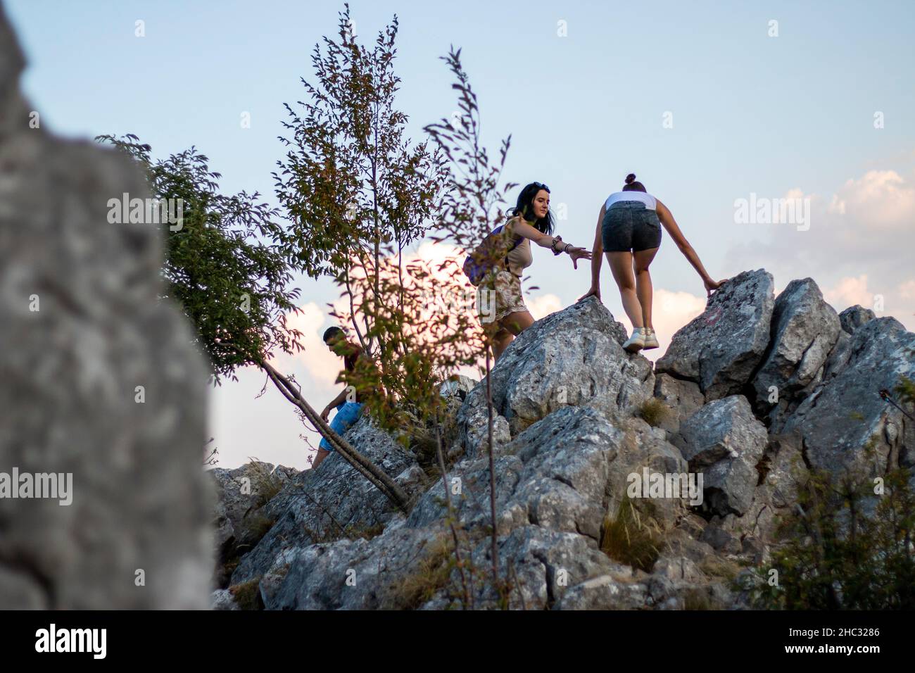Two young womans is climbing on hill Stock Photo - Alamy