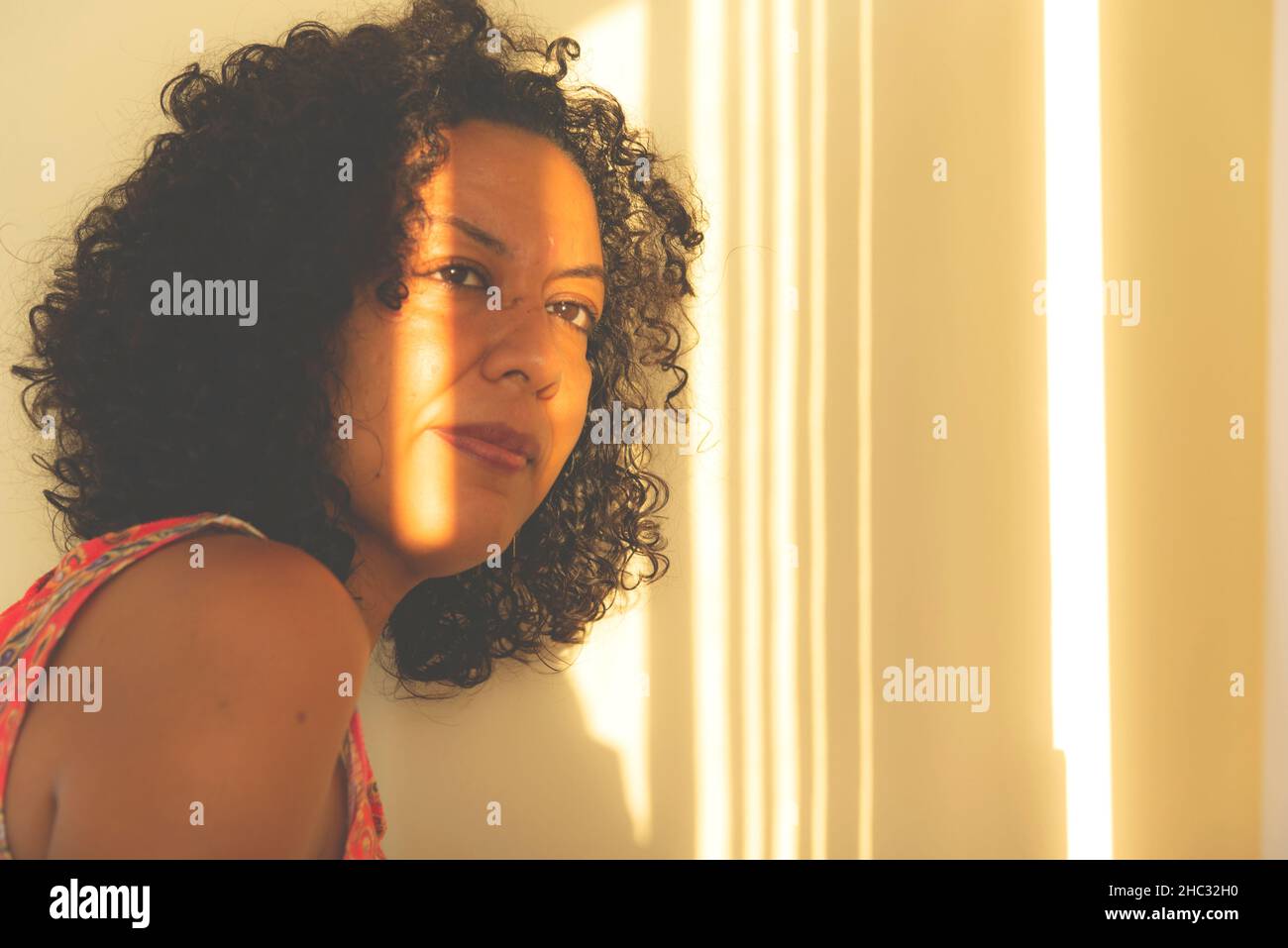 Portrait of a woman's face with light and shadows from the window. Salvador, Bahia, Brazil. Stock Photo