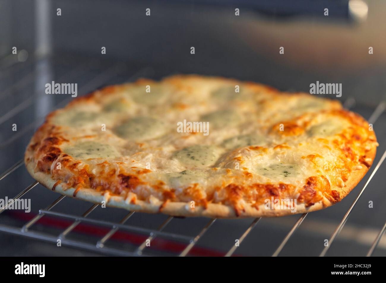 Homemade four cheese pizza in the oven Stock Photo