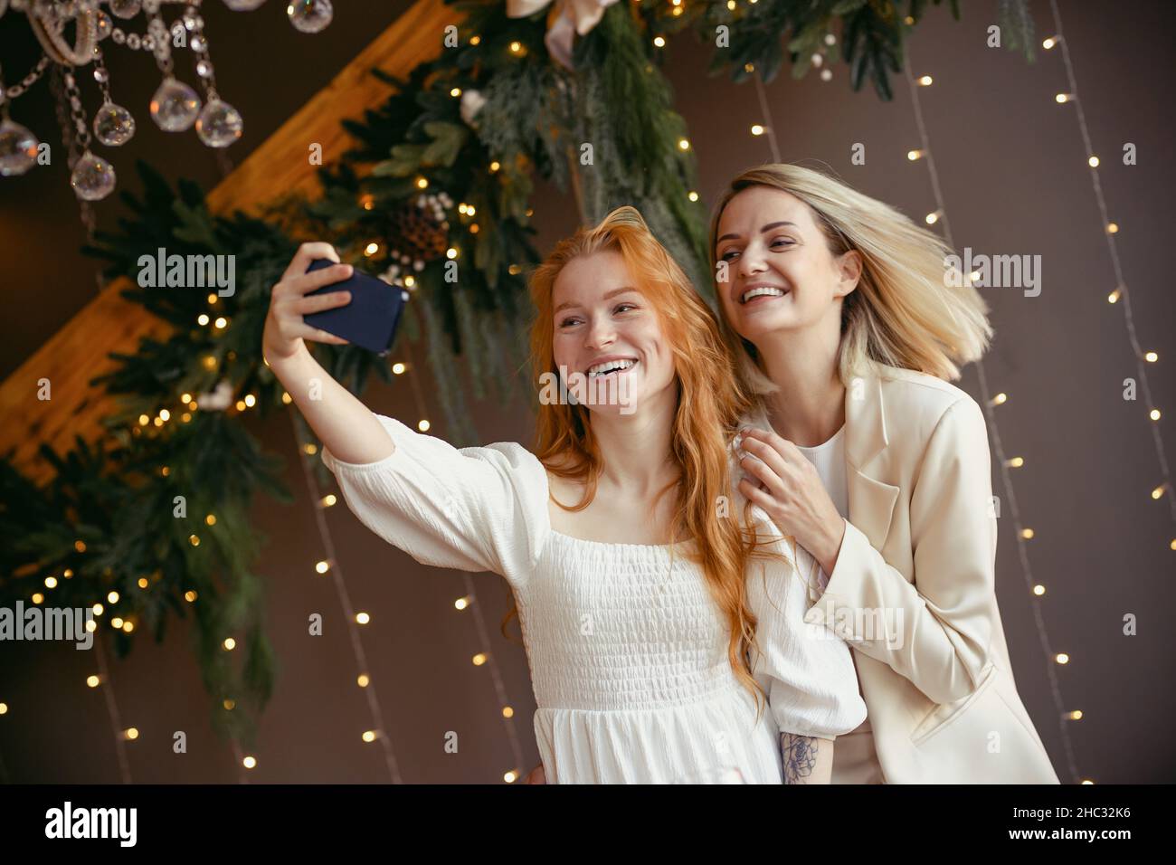 Lesbian couple takes a selfie on their phone, girls smile and have a good time together. Stock Photo