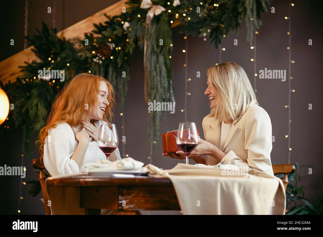lesbian couple having dinner in a restaurant Girl giving a gift to her sweetheart Stock Photo