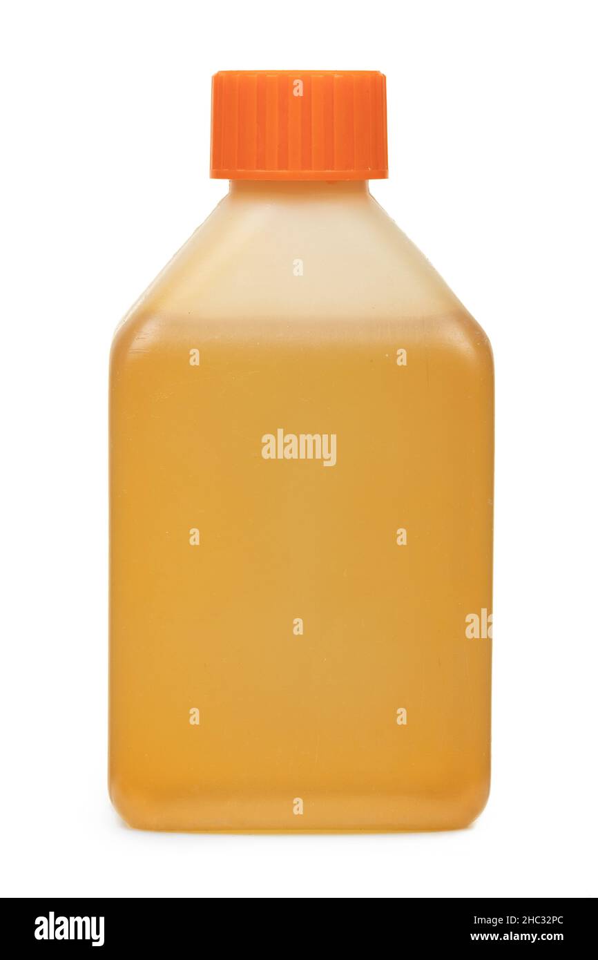 Plastic transparent bottle with orange cap, filled with yellow liquid, no label, isolated on white background Stock Photo