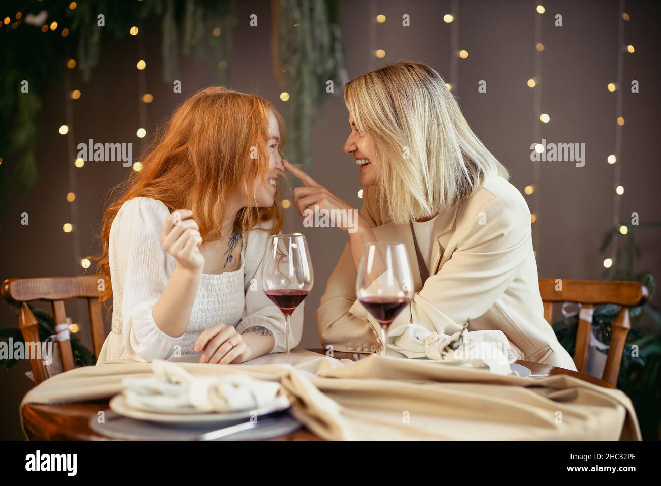 lesbian couple having dinner in a restaurant Girls drink wine and talk Stock Photo