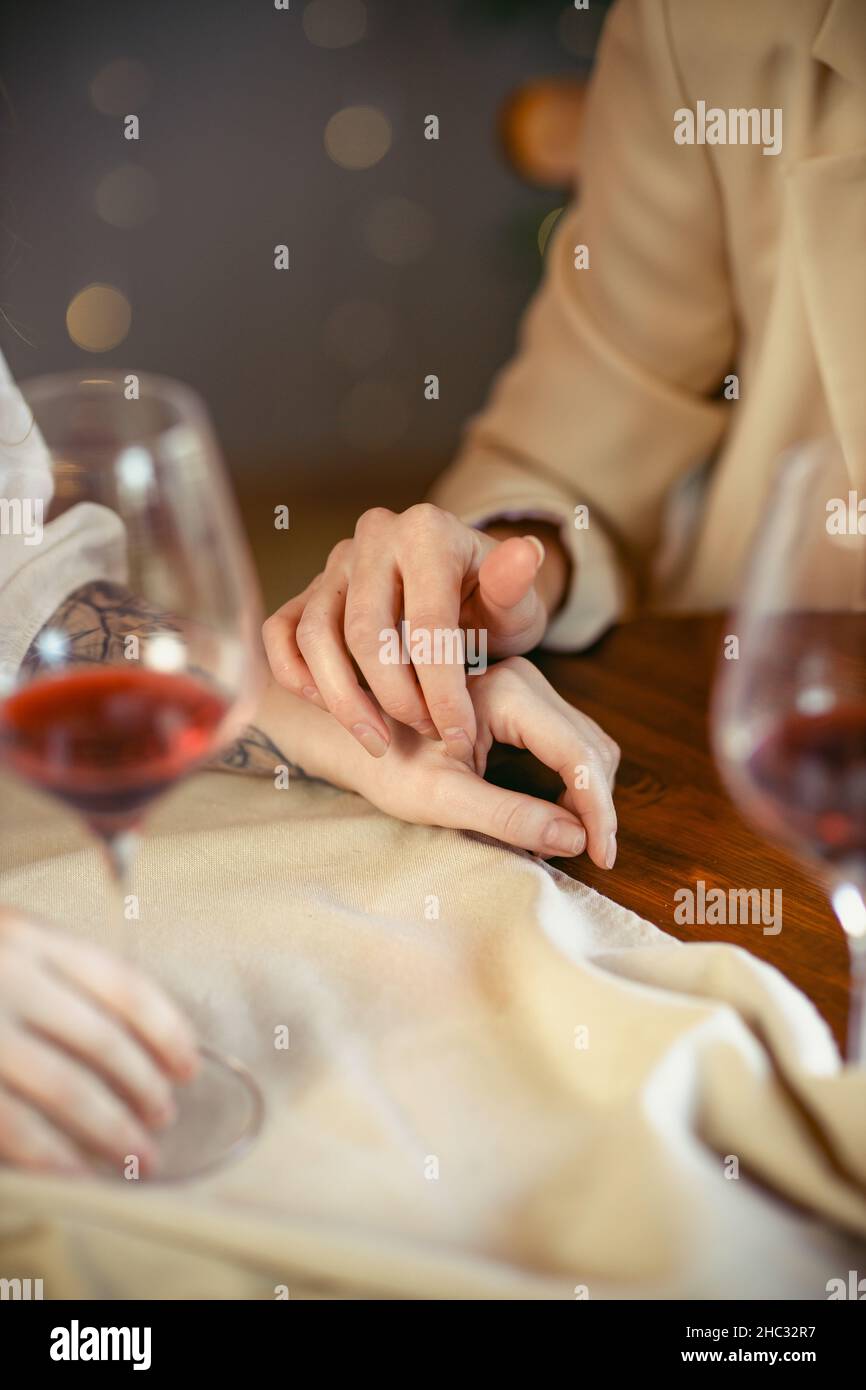lesbian couple having dinner in a restaurant Close-up of hands of a loving couple Stock Photo