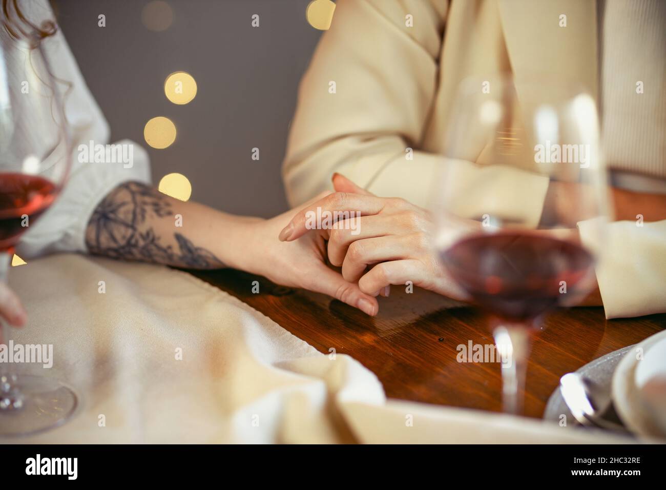 lesbian couple having dinner in a restaurant Close-up of hands of a loving couple Stock Photo