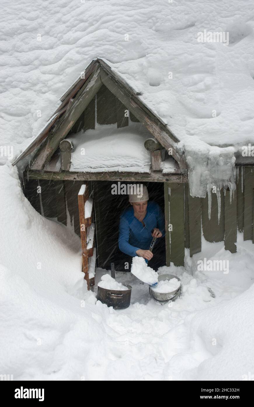 single woman shoveling snow. Mt Hood, Oregon Stock Photo