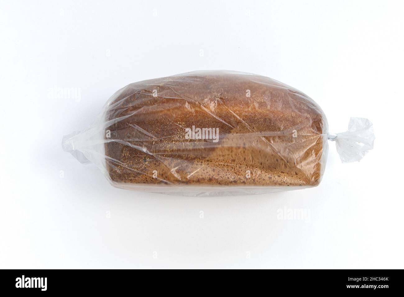bread in plastic bag, whole loaf in transparent package isolated on white background, top view Stock Photo