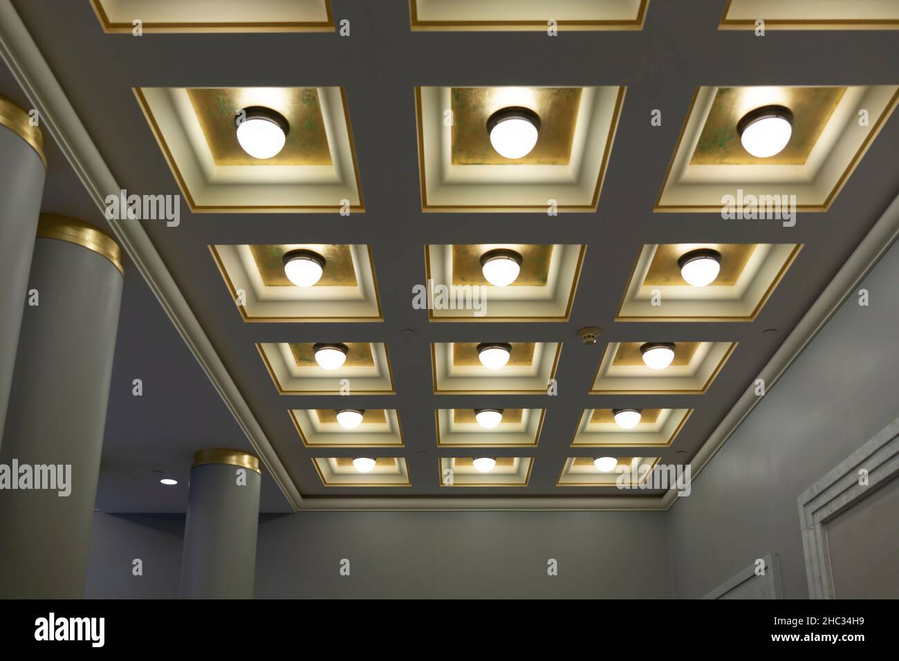 Geometric ceiling with square boxes and round lamps in a row and column of  hall Stock Photo - Alamy
