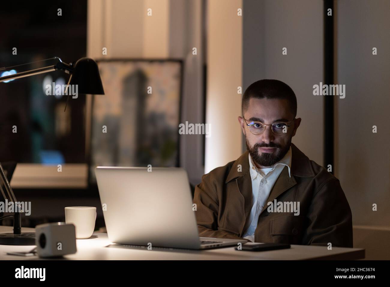 Overwork before project deadline: casual man programmer or web developer staying late in office Stock Photo