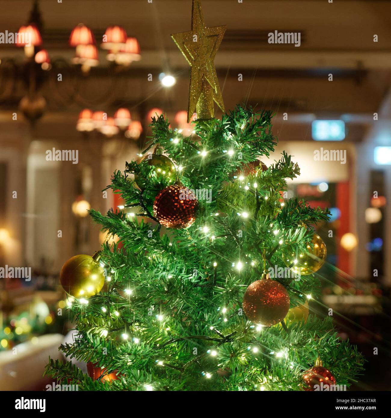 London, Greater London, England, December 15 2021: Top of a Christmas Tree with decorations and a star in a restaurant. Stock Photo