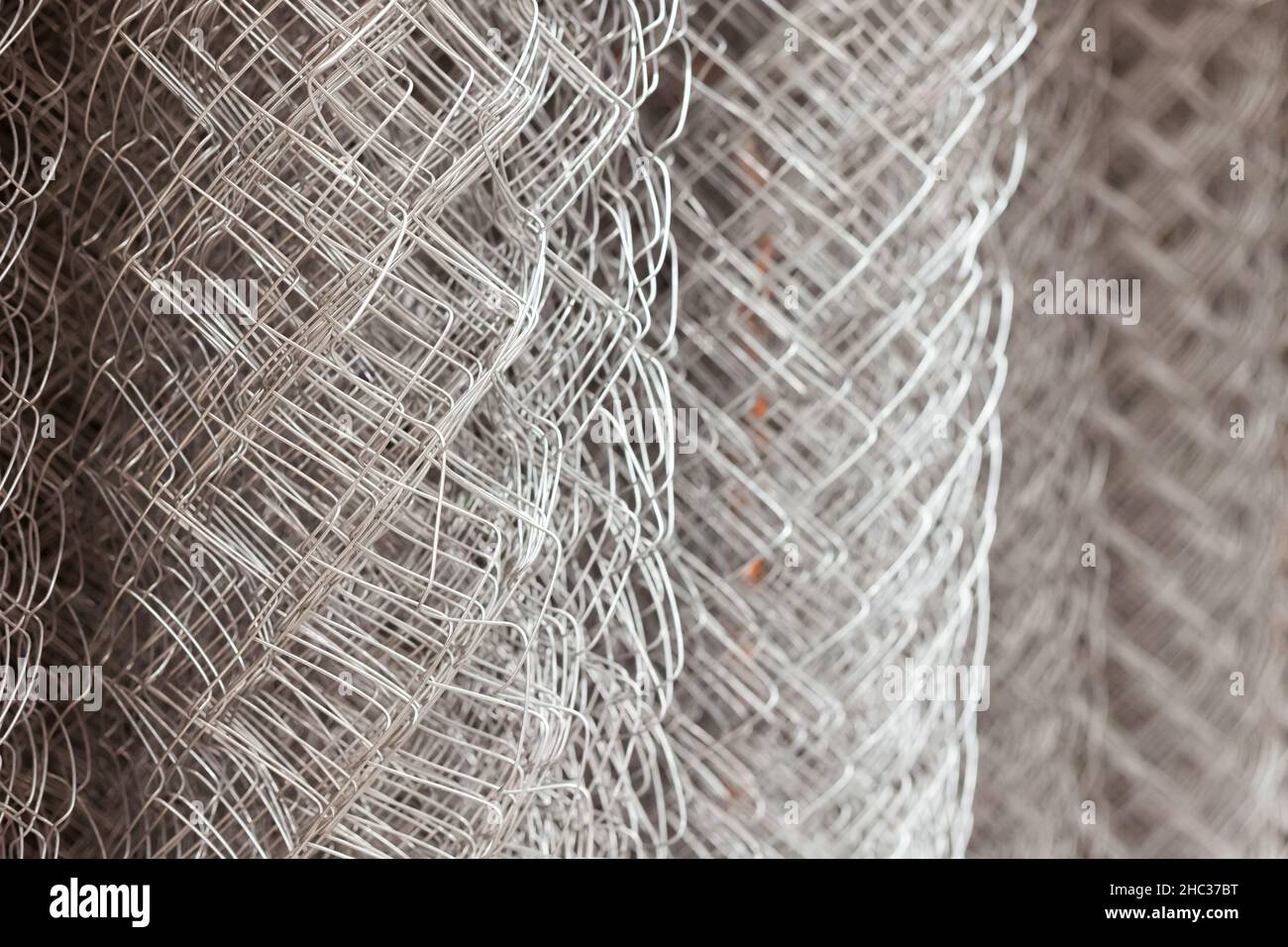 Metal mesh netting rolled into rolls. Rolled chain-link fence. Stock Photo
