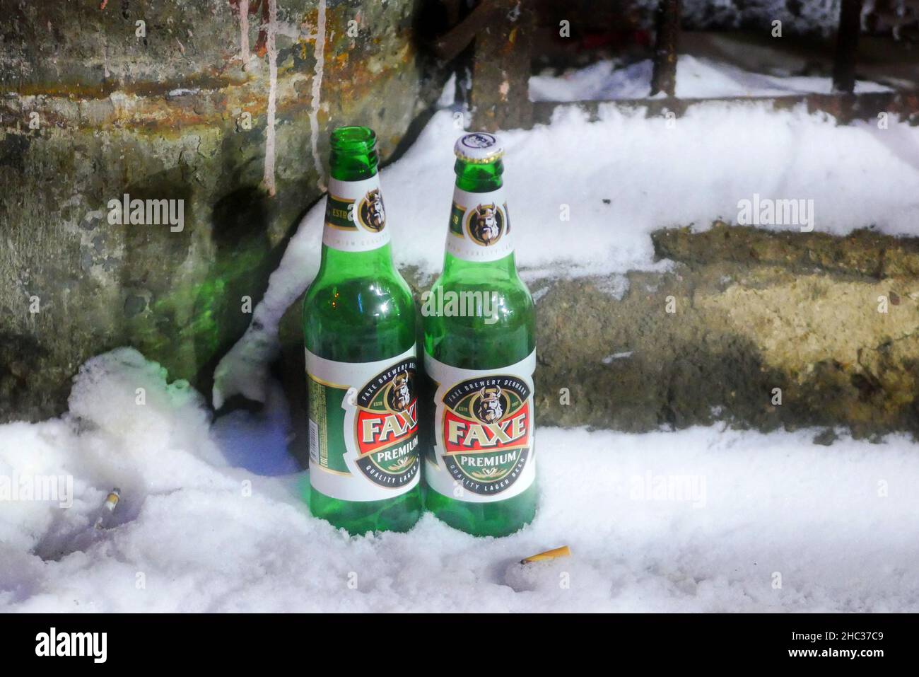 Moscow, Russia - December 14, 2021: Winter,  Two glass green empty beer bottles in the snow, brand strong beer'Faxe Brewery' - Danish Brewing Company, Stock Photo