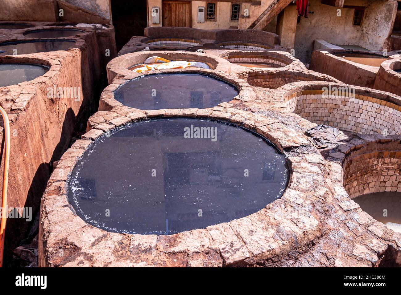 Dyed water fill in tanks in empty tannery and old building Stock Photo