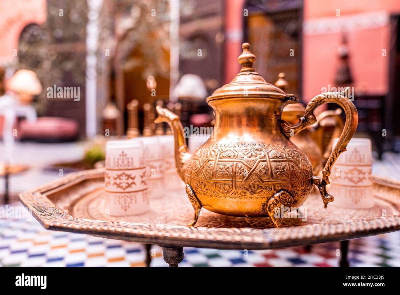 Traditional ornate copper teapot with glasses on table Stock Photo - Alamy
