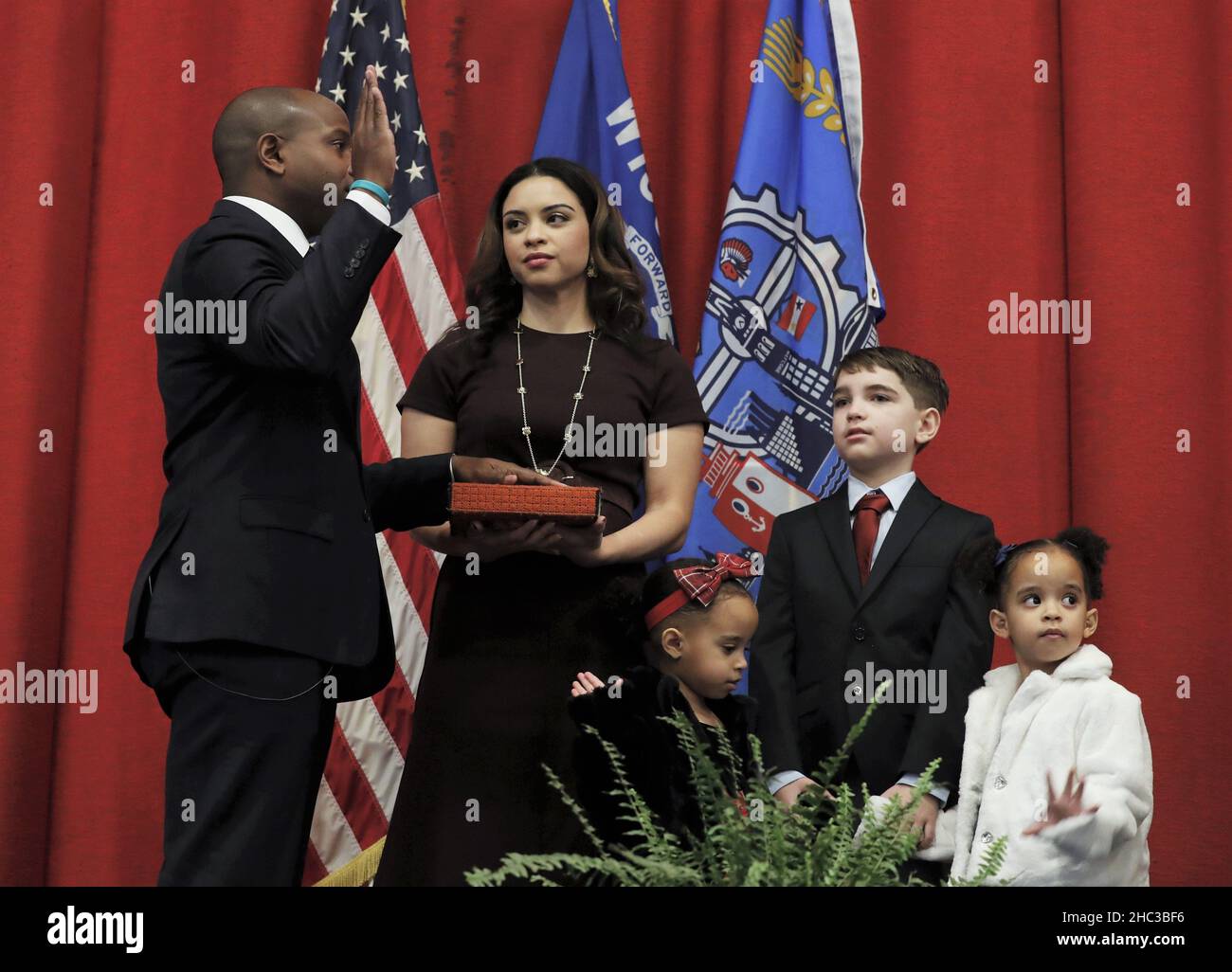 Milwaukee, Wisconsin, USA. 23rd Dec, 2021. Incoming Milwaukee Mayor CAVALIER JOHNSON being sworn in by his wife DOMINIQUE while their three children watch at Bay View high school auditorium, Thursday December 23, 2021. CAVALIER JOHNSON was appointed mayor when previous mayor Tom Barrett resigned when he was nominated ambassador to Luxembourg by the senate recently. (Credit Image: © Pat A. Robinson/ZUMA Press Wire) Stock Photo
