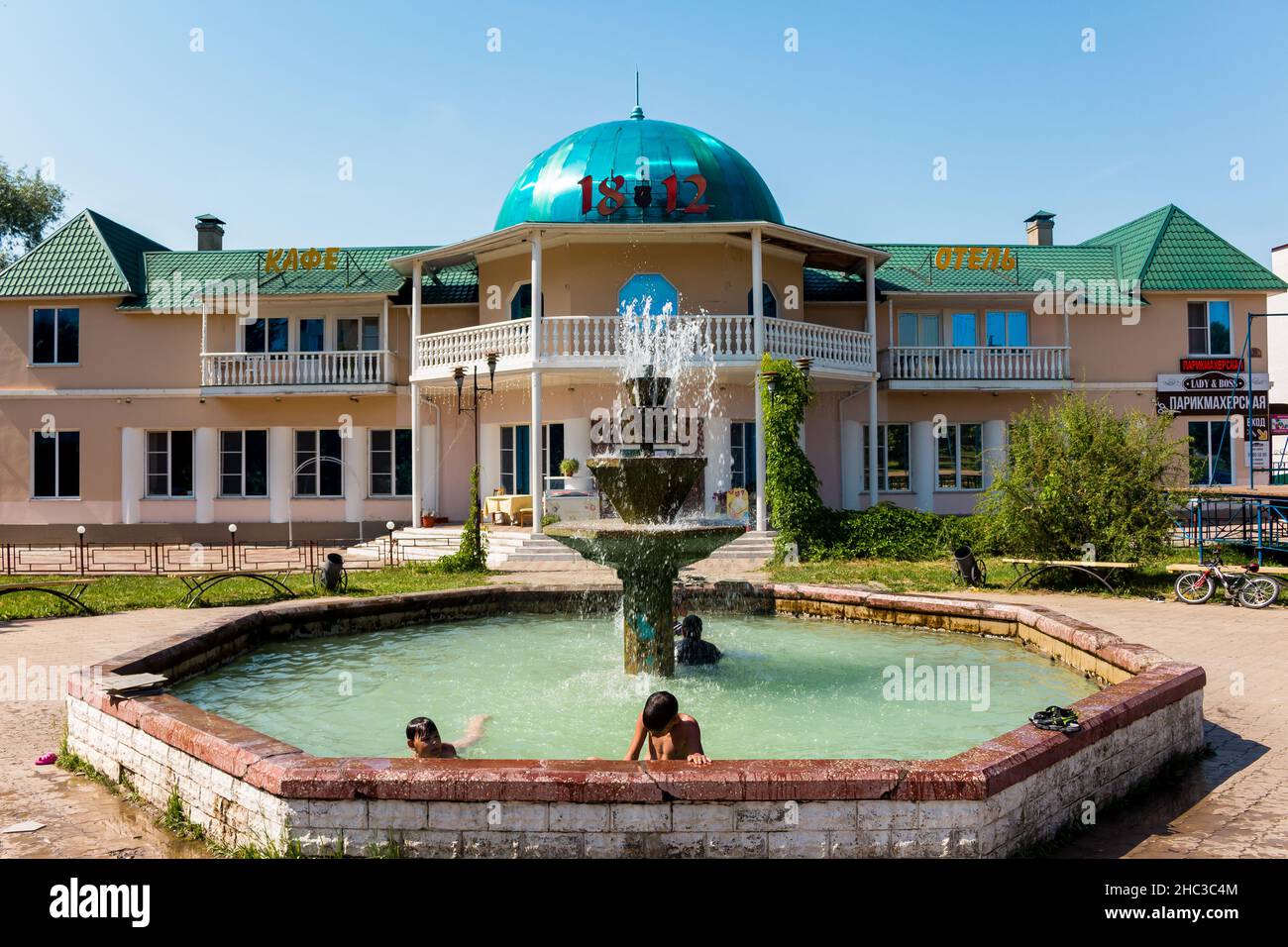 Fountain on the territory of the city square, children bathing in the fountain: Maloyaroslavets, Russia - June 2021 Stock Photo
