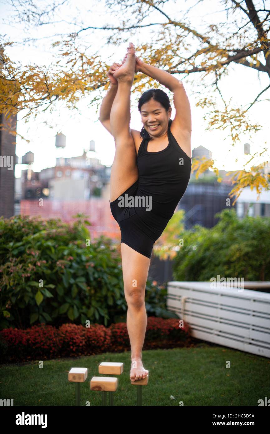 Smiling female gymnast balancing on one leg outdoors Stock Photo Alamy
