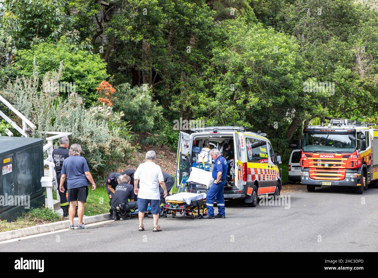 Sydney ambulance paramedic and fire personnel attend to an elderly lady who is being stretchered into the ambulance,Avalon Beach,Australia Stock Photo