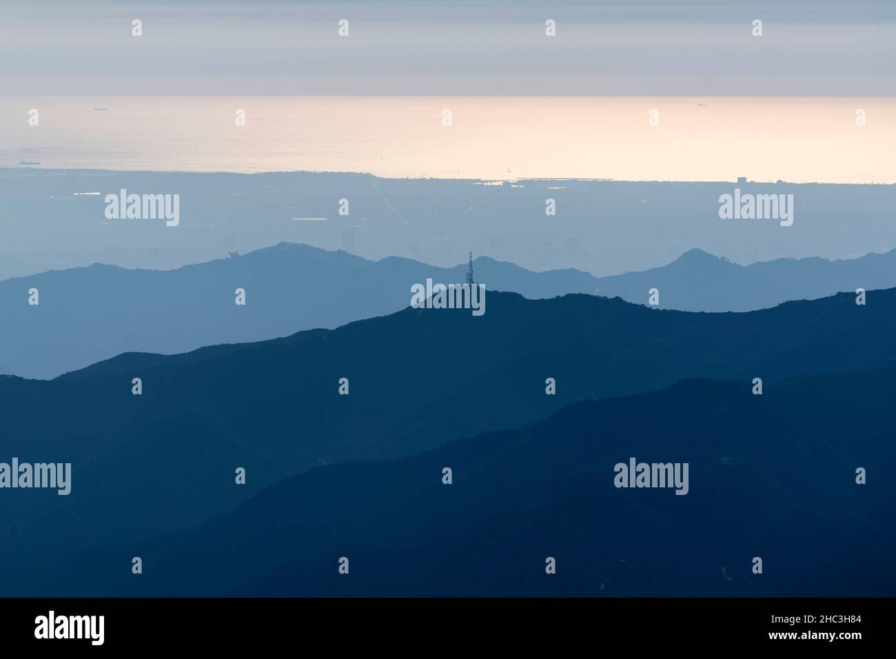 Mountain ridges with the shimmering Pacific ocean in distance. Shot