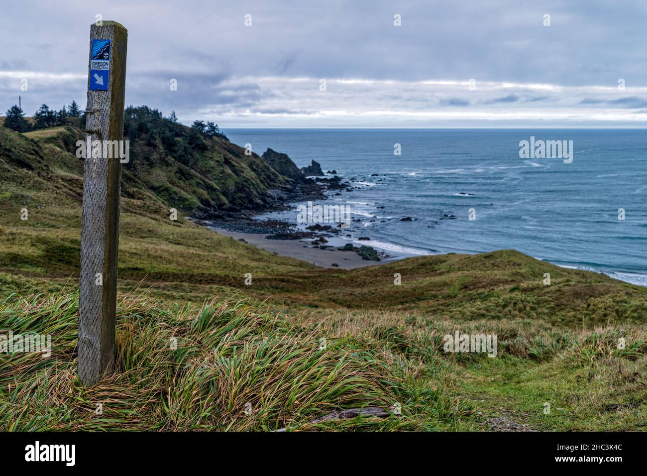 A wood post marks the Oregon Coast Trail at Cape Blanco State Park in Oregon, USA Stock Photo