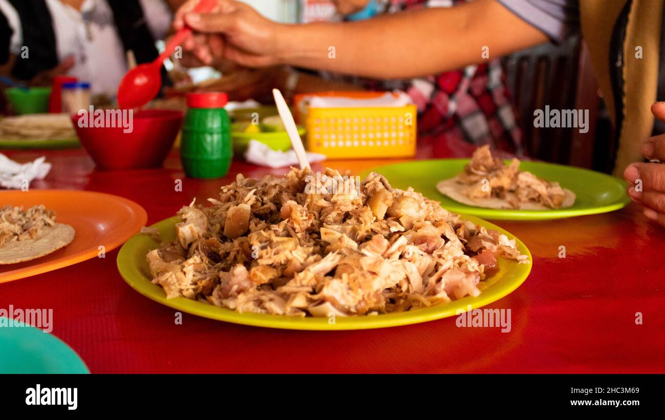 man making salsa to his carnitas tacos traditional Mexican from Michocan. High quality photo Stock Photo