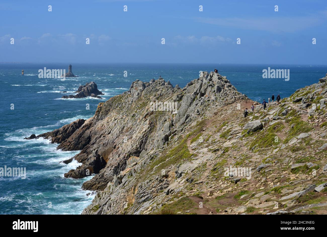 Pointe du Raz, Brittany, France atlantic view and light towers, people hiking at the cliffs Stock Photo