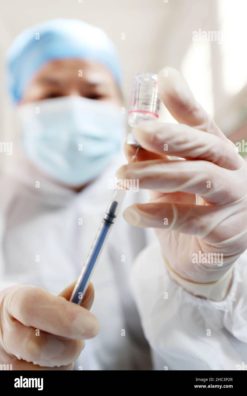 LIUZHOU, CHINA - DECEMBER 12, 2021 - A health care worker prepares a 'booster needle' at a centralized vaccination site for COVID-19 vaccines in Liuzh Stock Photo
