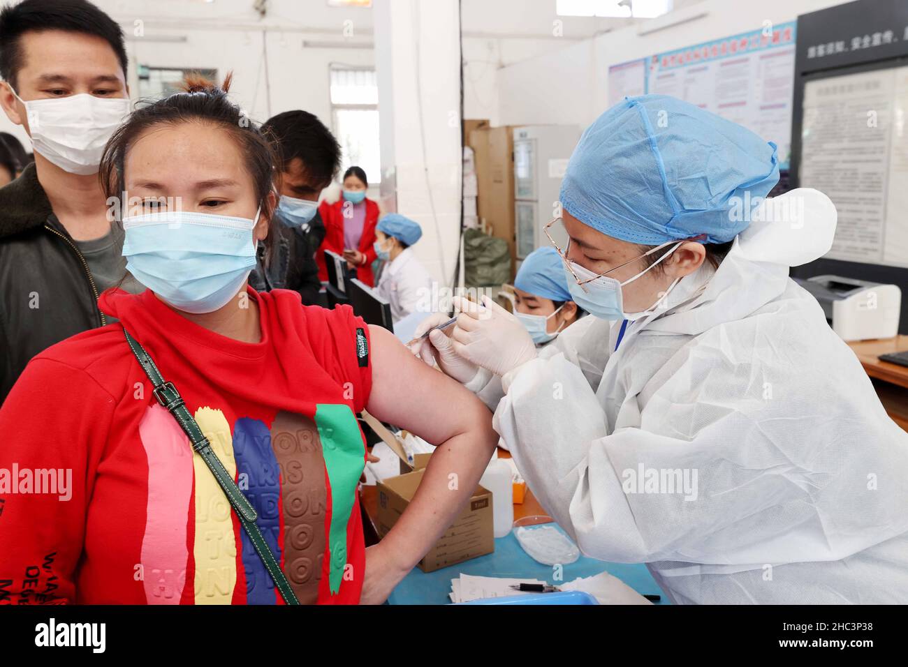 LIUZHOU, CHINA - DECEMBER 12, 2021 - Medical workers administer 'booster needle' at a centralized vaccination site for COVID-19 vaccine in Liuzhou, Gu Stock Photo