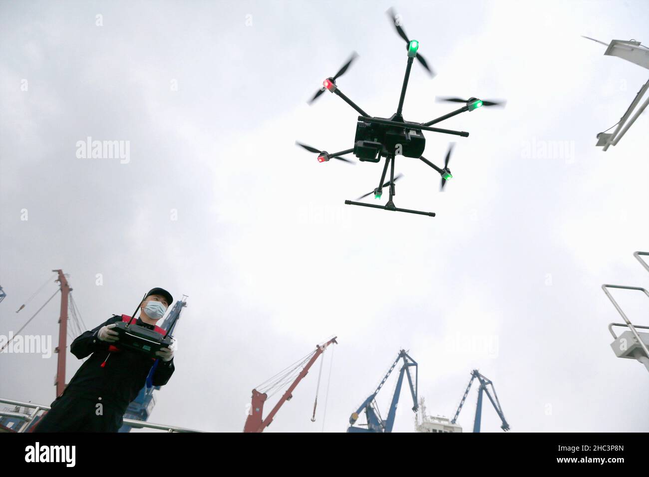 NANJING, CHINA - DECEMBER 24, 2021 - A police officer operating a police drone at an entry border control station prepares to carry out an aerial call Stock Photo