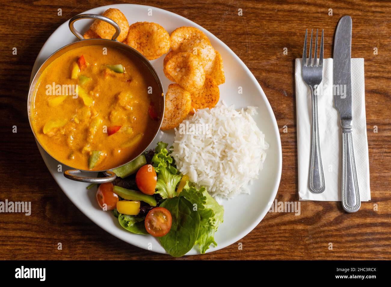Top view of delicious lunch with rice, soup with colorful peppers, and salad Stock Photo